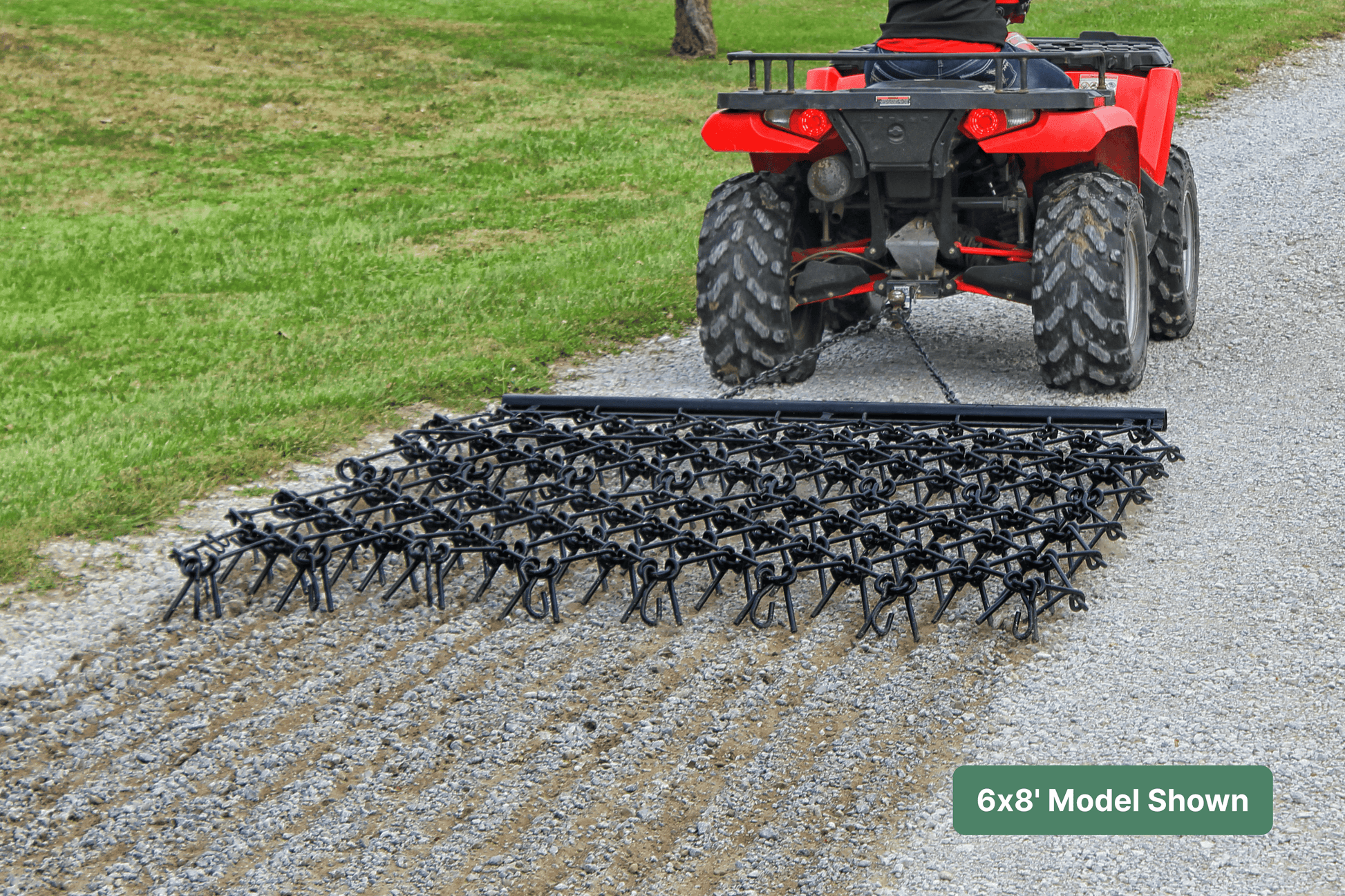 ATV with drawbar harrow on an agricultural gravel path next to grass